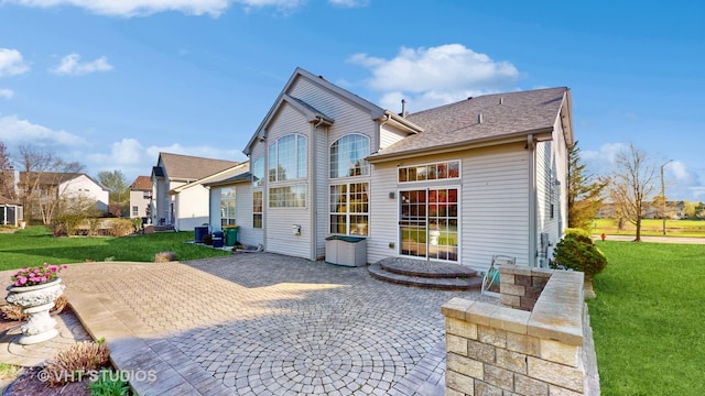 rear view of house with a yard and a patio