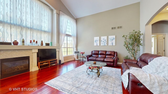 living room with high vaulted ceiling, dark wood-type flooring, and a fireplace