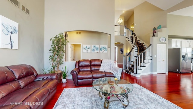 living room with a high ceiling and dark hardwood / wood-style flooring