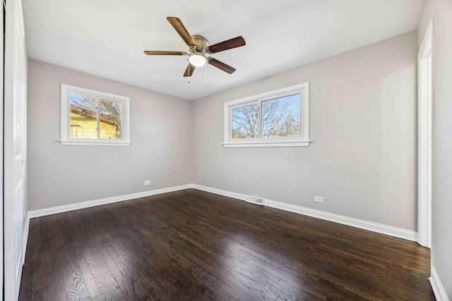 spare room with ceiling fan, plenty of natural light, and dark hardwood / wood-style floors