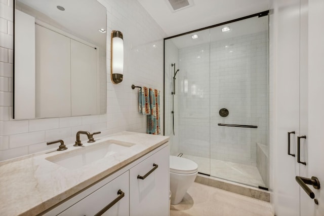 bathroom with vanity, decorative backsplash, tile walls, toilet, and a shower with shower door