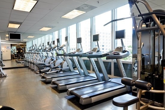 gym with a paneled ceiling and expansive windows