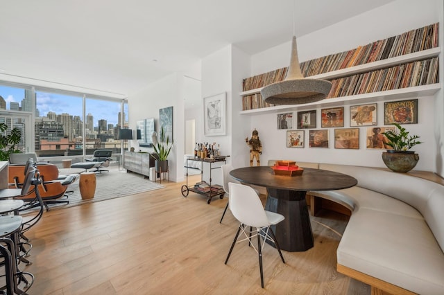 dining room featuring light wood-type flooring and floor to ceiling windows