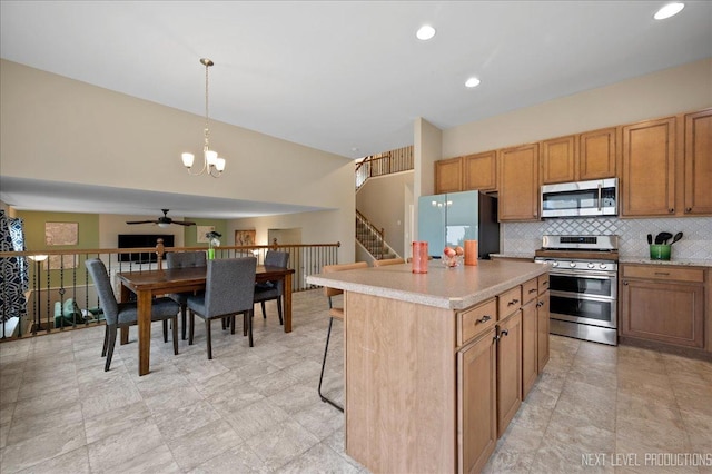 kitchen featuring a kitchen island, pendant lighting, tasteful backsplash, a kitchen breakfast bar, and stainless steel appliances