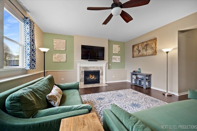 living room with dark wood-type flooring, a tile fireplace, and ceiling fan