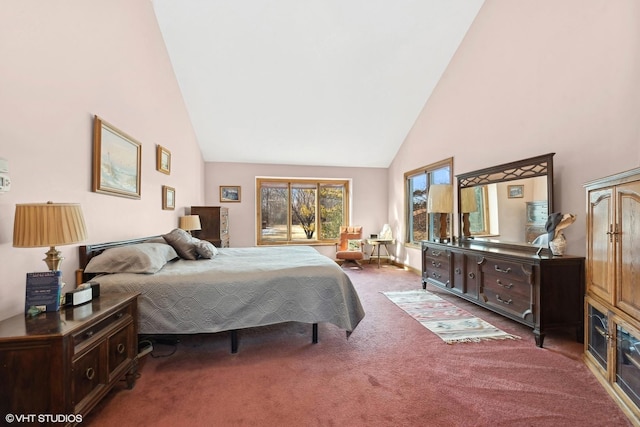 carpeted bedroom with high vaulted ceiling