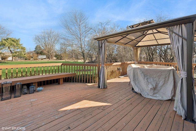 wooden terrace with a gazebo and a yard