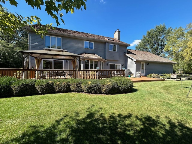 rear view of property with a gazebo, a yard, and a deck