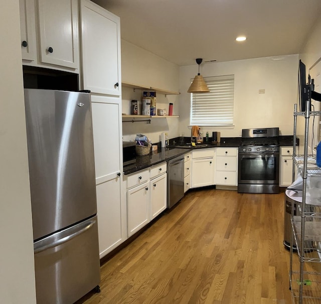 kitchen featuring stainless steel appliances, pendant lighting, light hardwood / wood-style flooring, and white cabinets