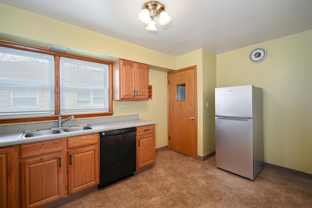 kitchen with dishwasher, sink, and stainless steel fridge