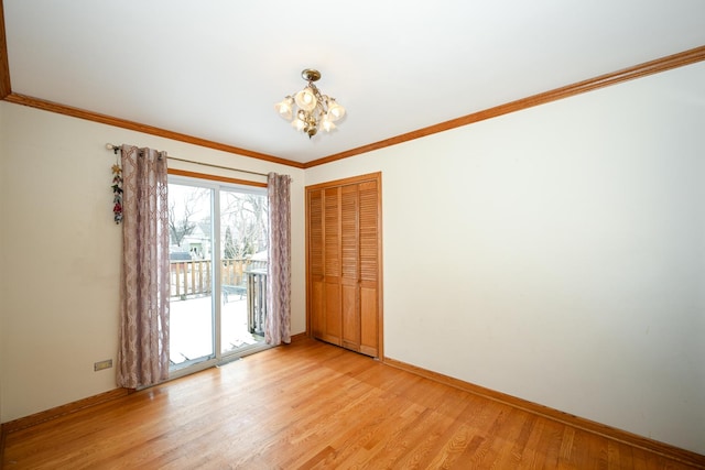 empty room featuring crown molding, an inviting chandelier, and light hardwood / wood-style floors