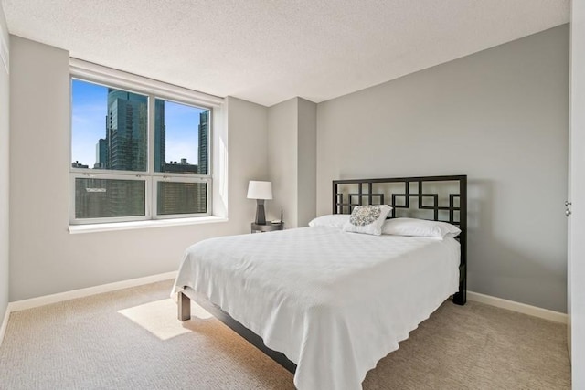 bedroom featuring a textured ceiling and light carpet