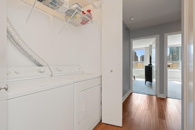 washroom with washing machine and dryer and light wood-type flooring