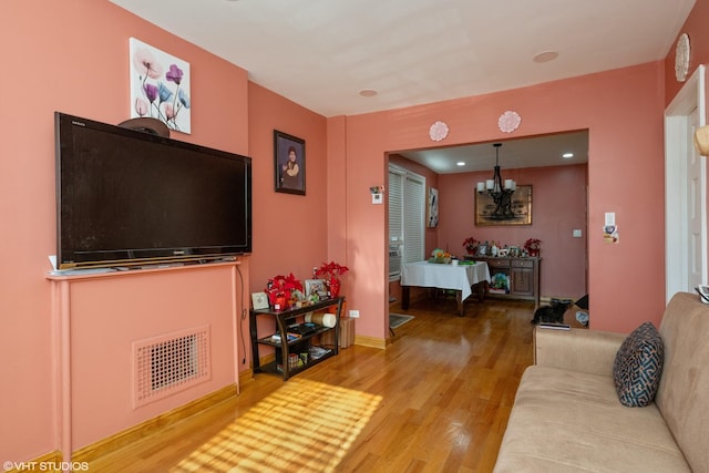 living room with an inviting chandelier and wood-type flooring