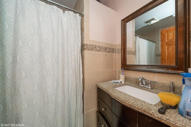 bathroom with vanity and tile walls