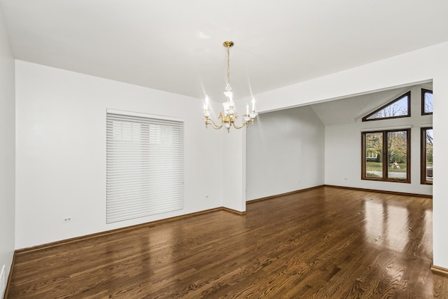 empty room with lofted ceiling, dark hardwood / wood-style floors, and a chandelier