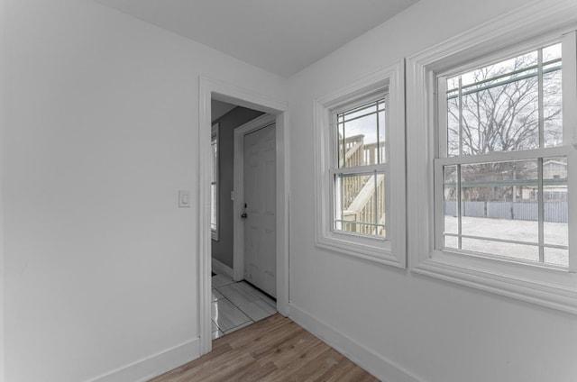 corridor featuring a wealth of natural light and light wood-type flooring