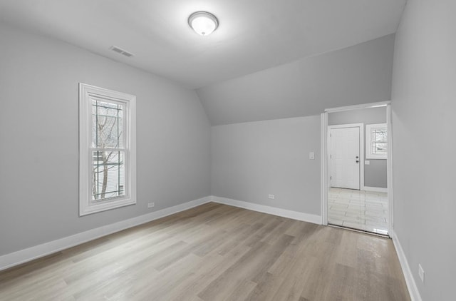 additional living space with lofted ceiling and light hardwood / wood-style floors