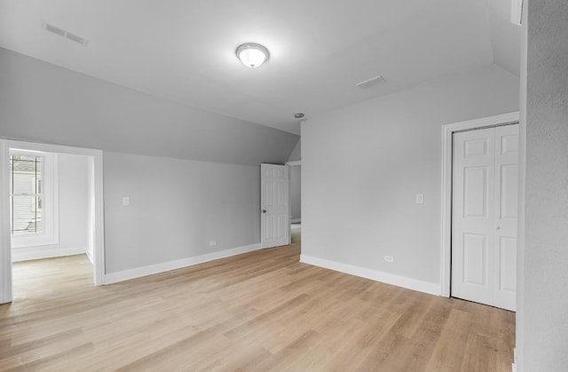 additional living space with lofted ceiling and light hardwood / wood-style floors