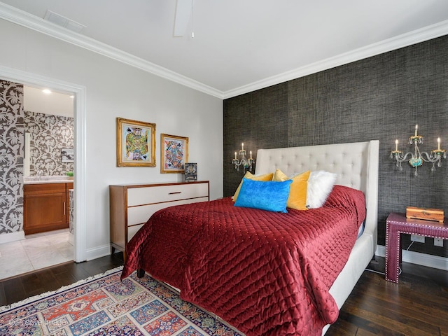 bedroom with hardwood / wood-style floors, crown molding, a notable chandelier, and ensuite bathroom