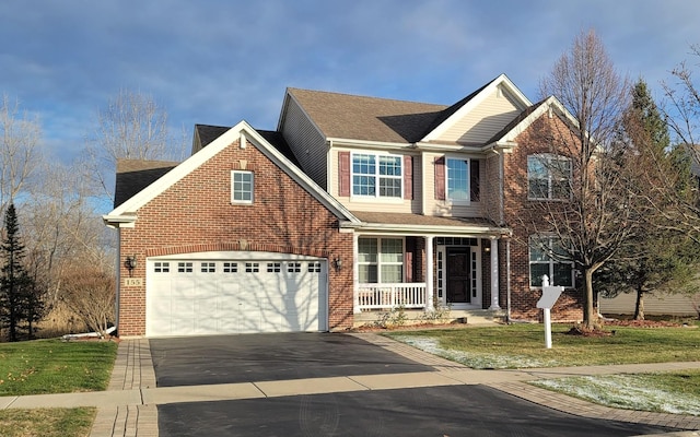 view of front property with a garage, a front yard, and a porch