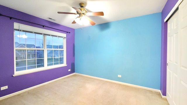 spare room with light carpet and ceiling fan