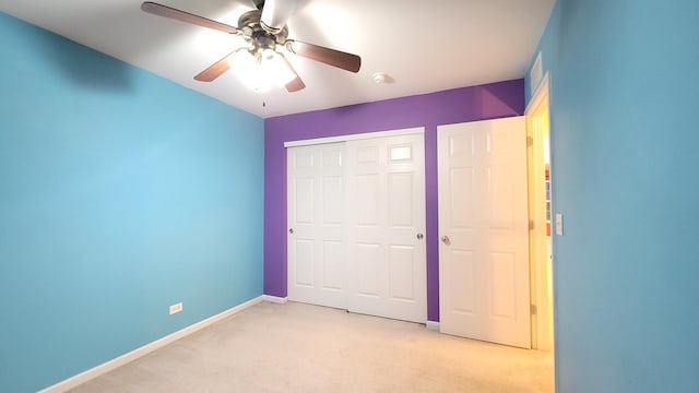 unfurnished bedroom with ceiling fan, light carpet, and a closet