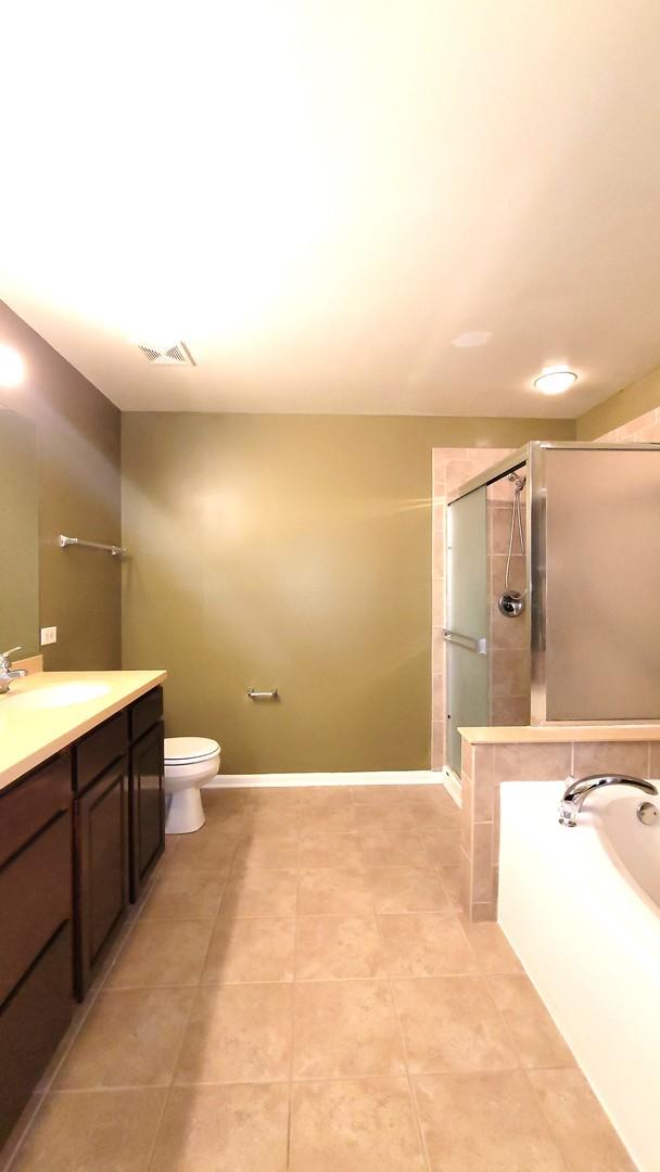 full bathroom with toilet, vanity, plus walk in shower, and tile patterned flooring