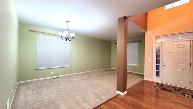 foyer entrance featuring hardwood / wood-style floors and a notable chandelier