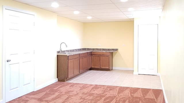 kitchen with light colored carpet, sink, and a drop ceiling