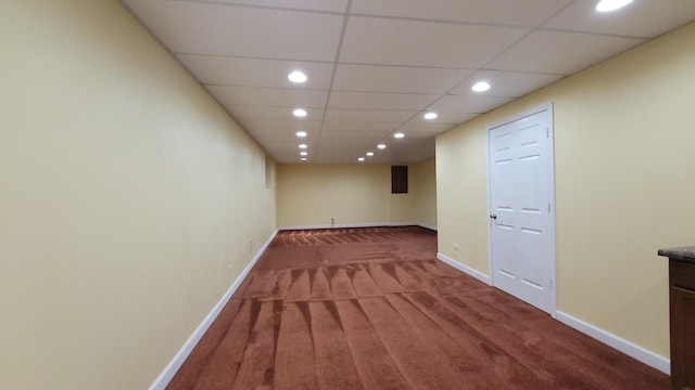 spare room featuring carpet and a paneled ceiling