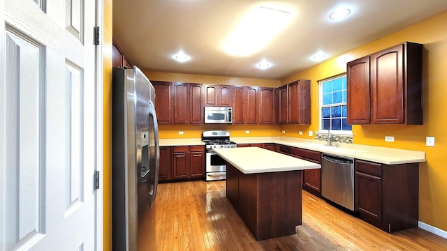 kitchen featuring light hardwood / wood-style floors, sink, stainless steel appliances, and a center island