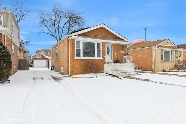 bungalow-style home with a garage and an outbuilding