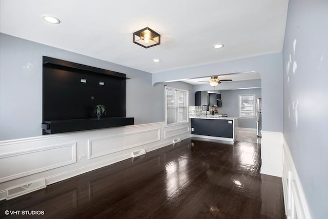 unfurnished living room featuring dark hardwood / wood-style flooring and ceiling fan