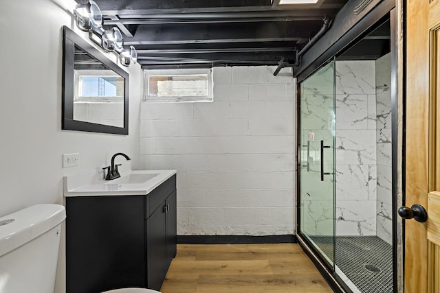 bathroom featuring hardwood / wood-style floors, toilet, a shower with door, and vanity