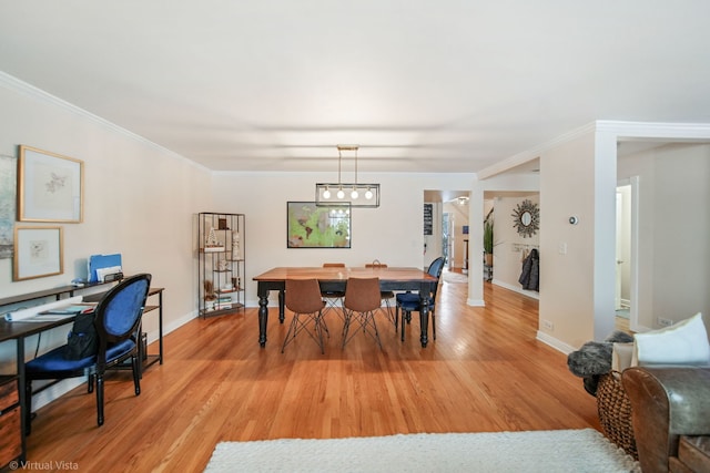 dining space featuring ornamental molding and light wood-type flooring