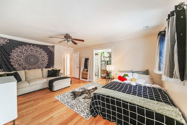 bedroom featuring wood-type flooring, ornamental molding, and ceiling fan