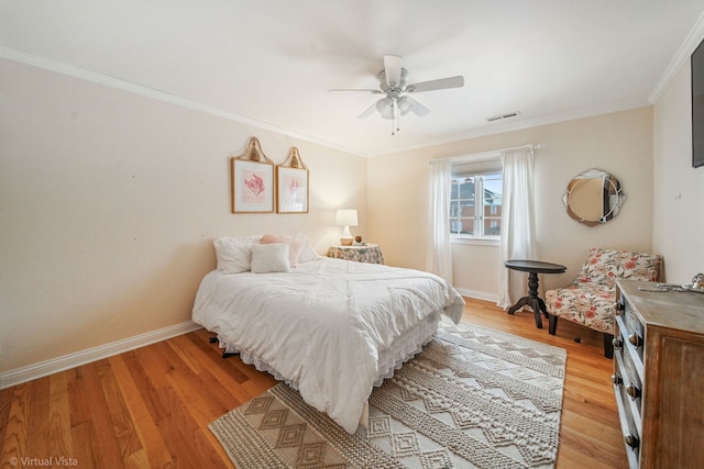 bedroom featuring crown molding, light hardwood / wood-style flooring, and ceiling fan