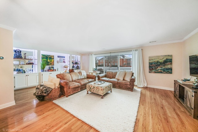 living room with crown molding and light hardwood / wood-style floors