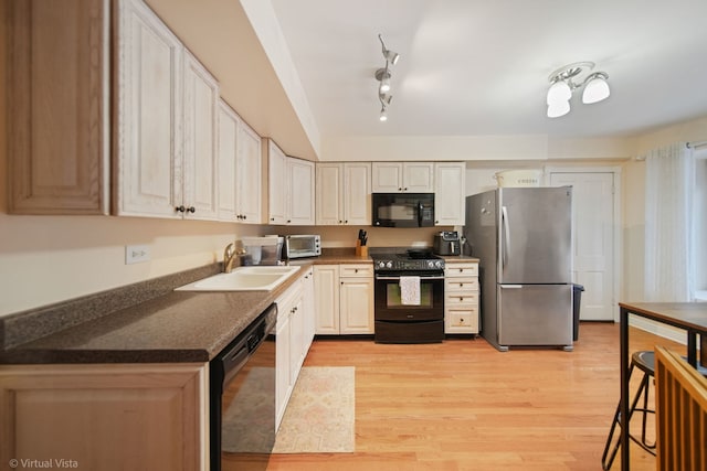 kitchen with sink, light wood-type flooring, and black appliances