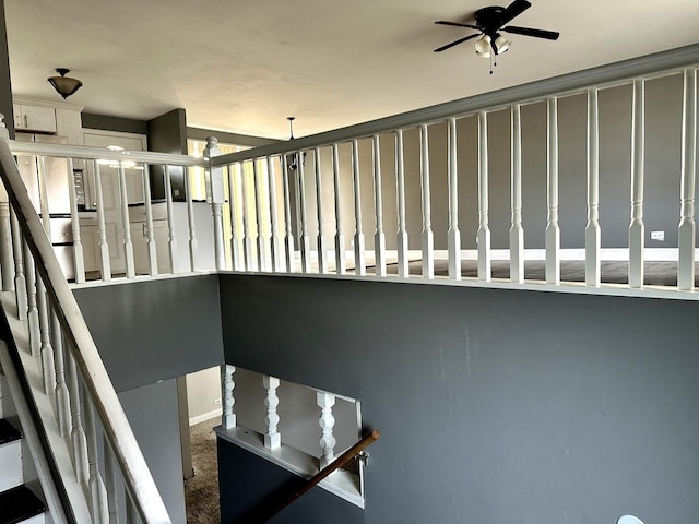 stairs featuring carpet floors and ceiling fan