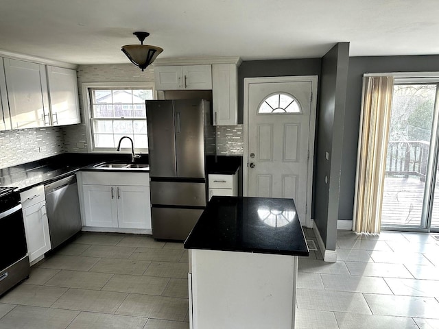 kitchen with white cabinets, sink, stainless steel appliances, and a kitchen island