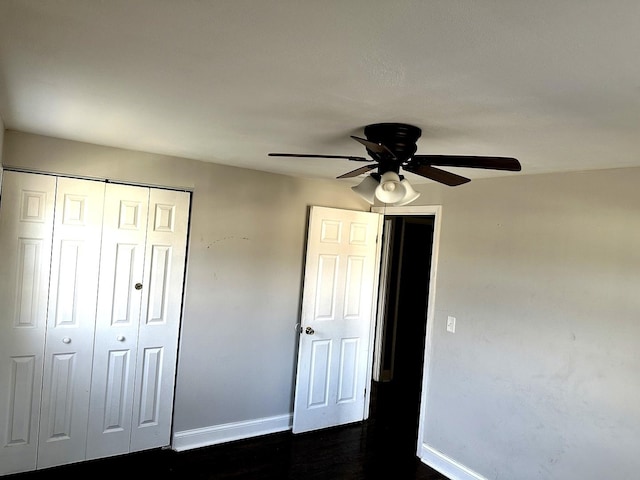 unfurnished bedroom with ceiling fan, a closet, and dark hardwood / wood-style floors