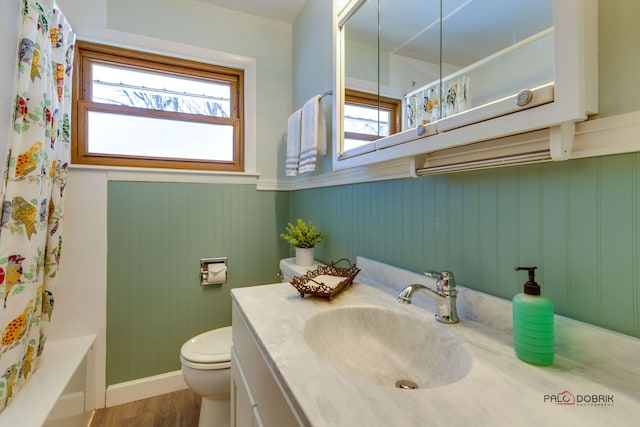 full bathroom featuring toilet, wood-type flooring, shower / bath combo, vanity, and wood walls