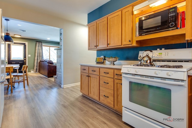 kitchen with light hardwood / wood-style floors, decorative light fixtures, and white gas range oven