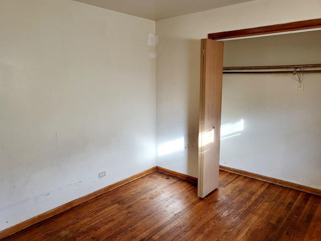 unfurnished bedroom featuring a closet and hardwood / wood-style floors