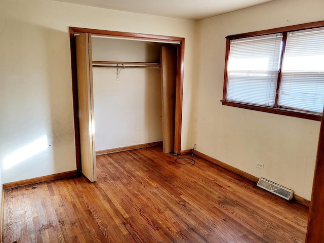 unfurnished bedroom featuring a closet and light hardwood / wood-style floors