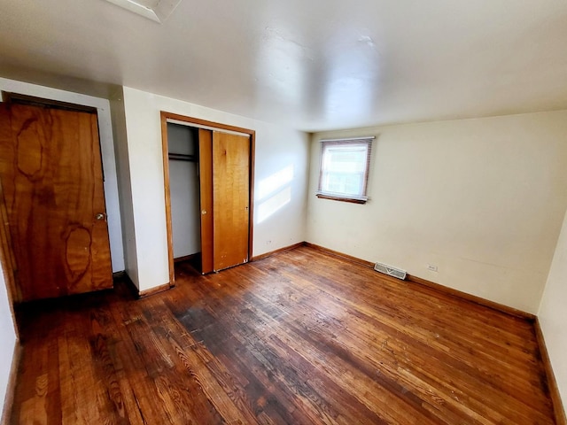 unfurnished bedroom with dark wood-type flooring