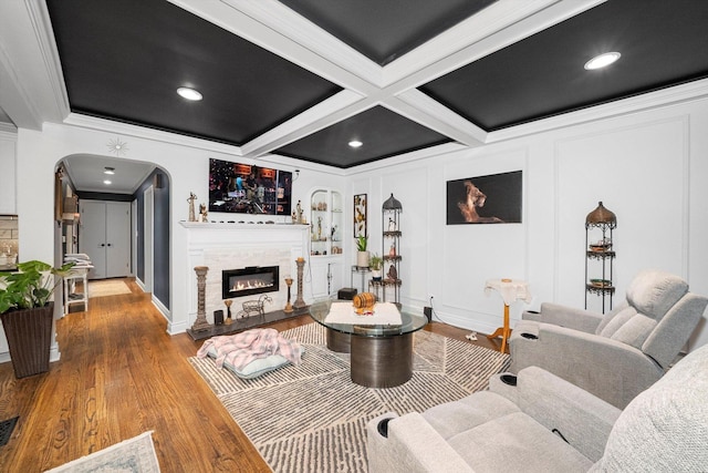 living room with a fireplace, wood-type flooring, beamed ceiling, crown molding, and coffered ceiling