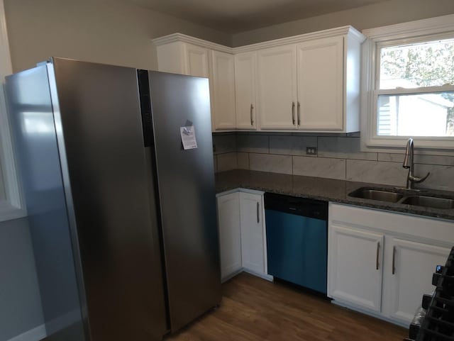 kitchen with white cabinets, appliances with stainless steel finishes, tasteful backsplash, dark stone countertops, and sink